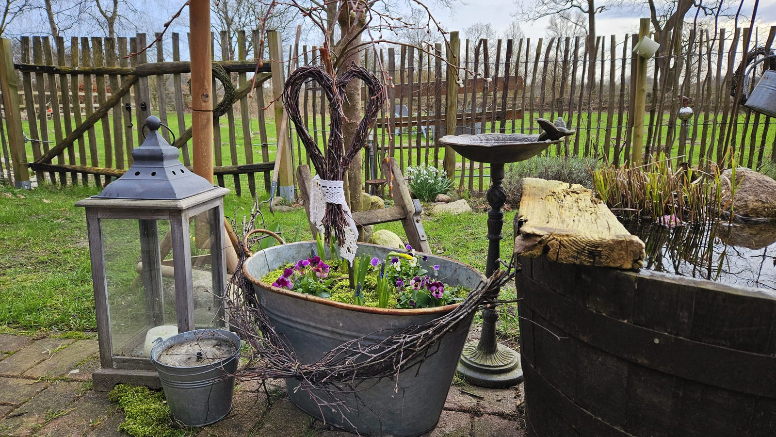 Frühlingsbeet in der Zinkwanne mit selbst gebundenen Herz aus Birkenreisig 