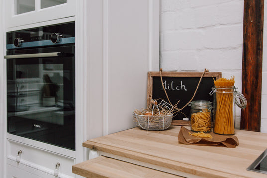 Romantique cuisine de campagne blanche avec armoire à four, plateau en chêne